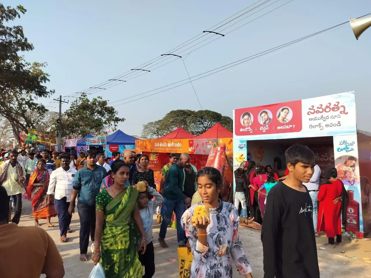 Pilgrims walking past branded sampling stalls at Medaram Jatara in Telangana