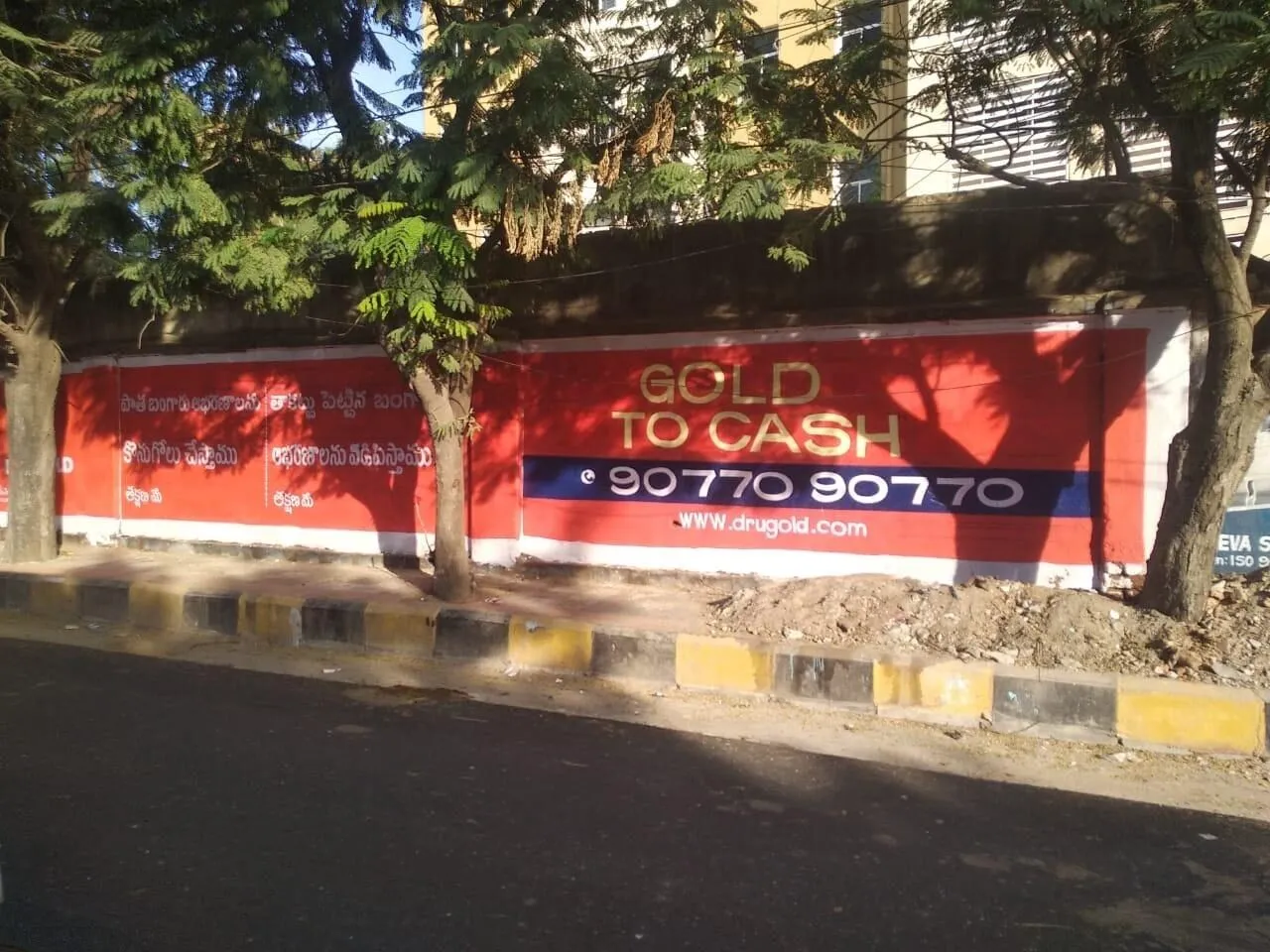 Low-rise compound wall painted with a gold loan brand message